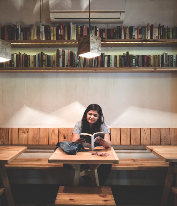 Studentin liest ein Buch in der Bibliothek