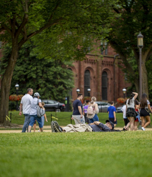 Studierende laufen über eine Wiese auf dem Campus
