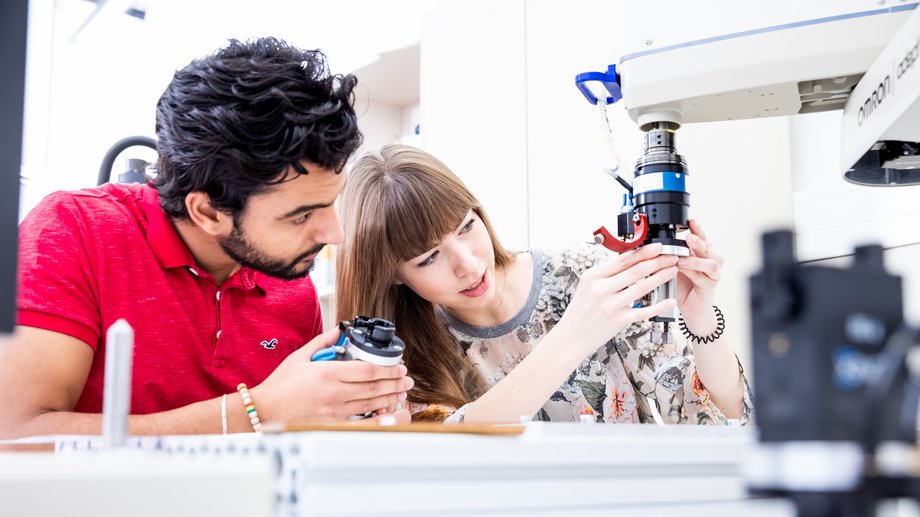 Zwei Studierende untersuchen gemeinsam ein Bauteil an einer Messmaschine im Labor der EAH Jena